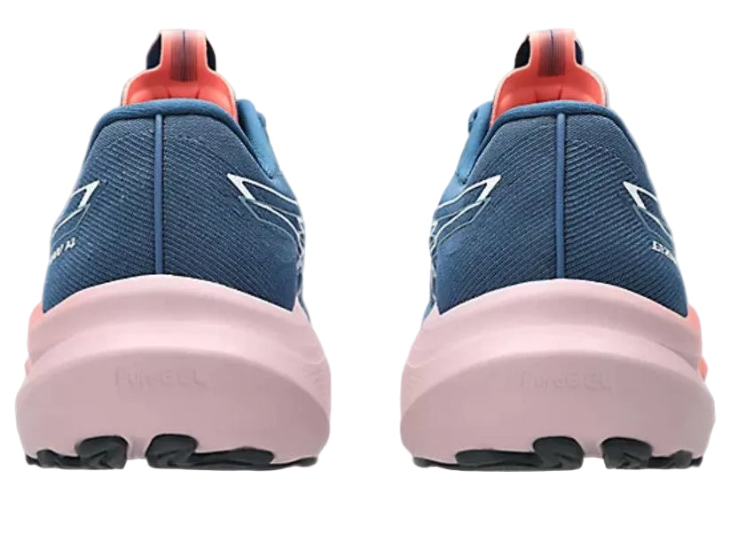 Blue running shoes with pink soles on a light gray background