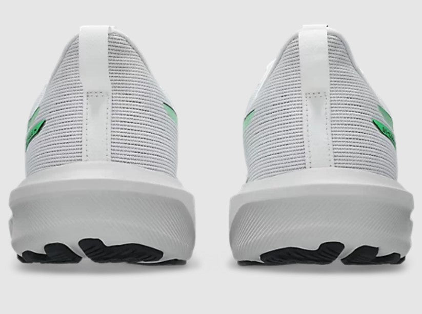 White sneakers with green accents on a light gray background