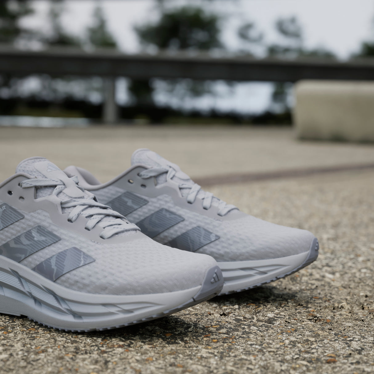 Gray athletic shoes on a concrete surface with a blurred background