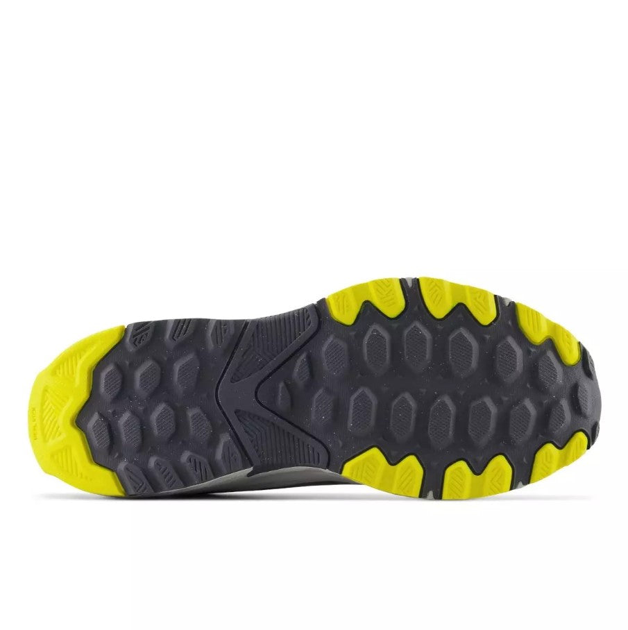 Close-up of a shoe sole with yellow and dark grey tread pattern on a white background