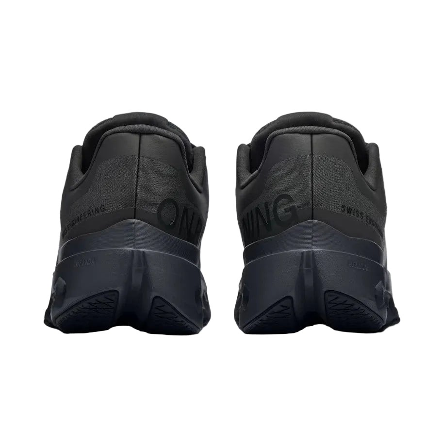 Black athletic shoes with brand logo on a light gray background