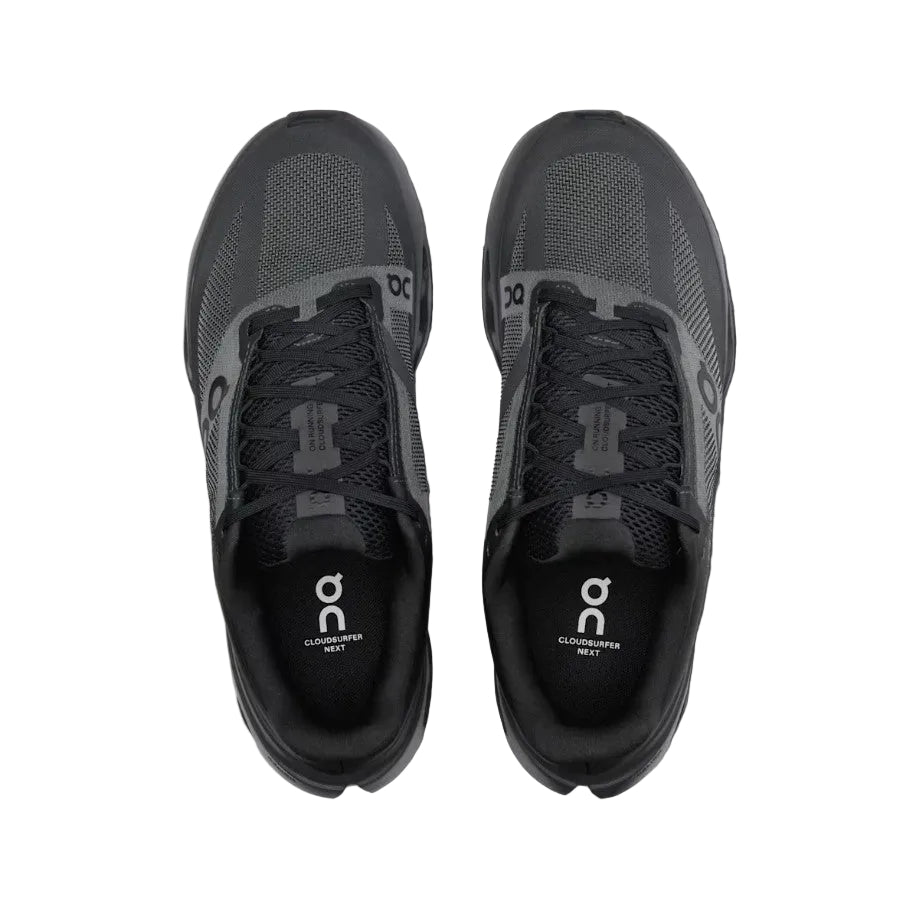 Pair of black running shoes with 'on' logo on a light gray background