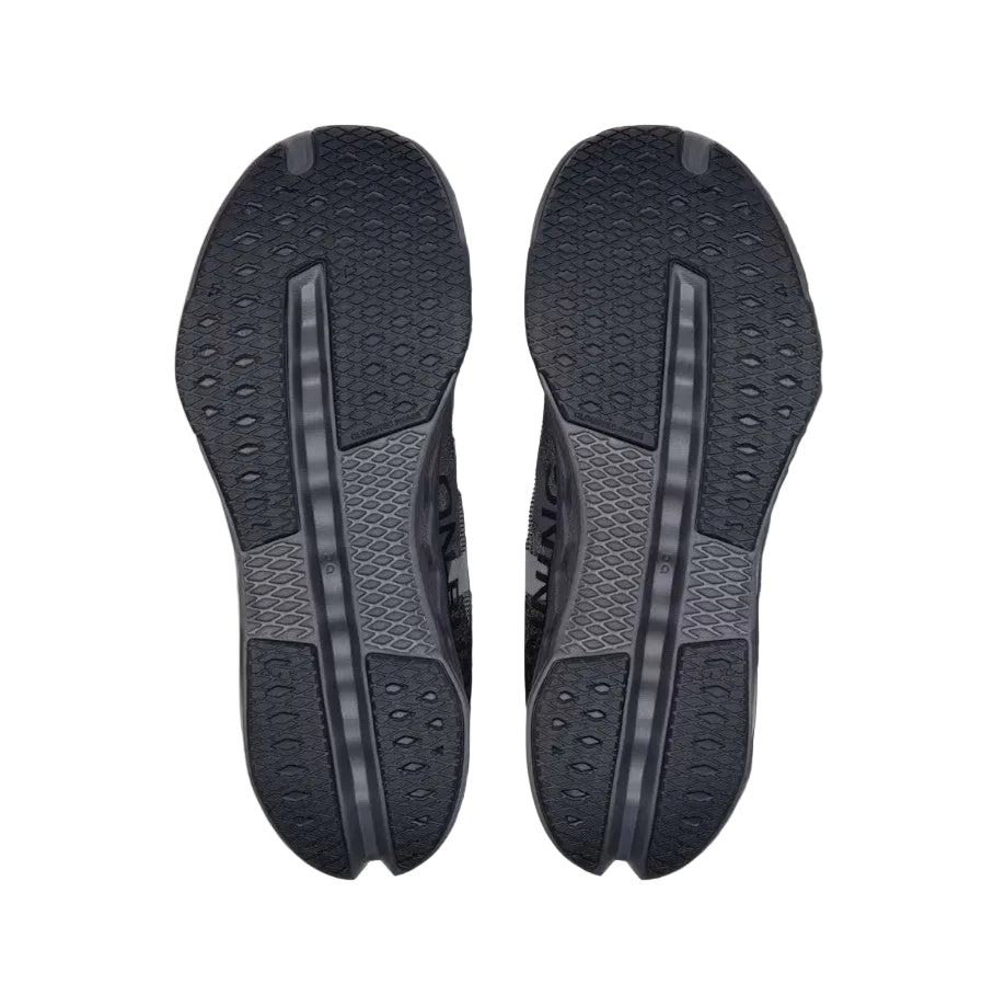 Black shoe sole with tread pattern on a light gray background