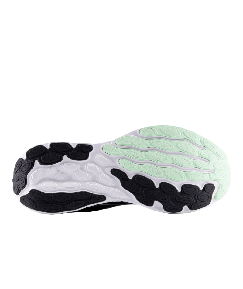 Close-up of a running shoe sole with black, white, and green design on a white background