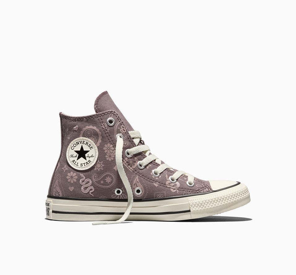 A single Converse All Star high-top sneaker in a dusty mauve-purple canvas with white floral and snake patterns, white laces, and a cream rubber toe cap and sole, shown against a plain white background.