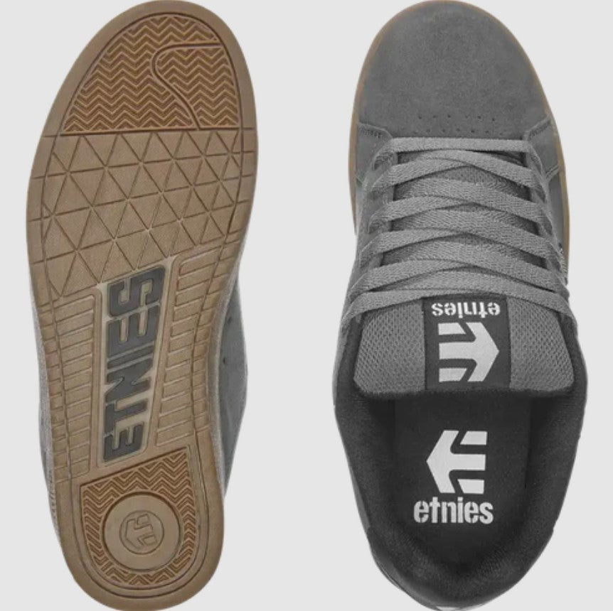 Gray sneakers with brown soles and Etnies logo on a white background