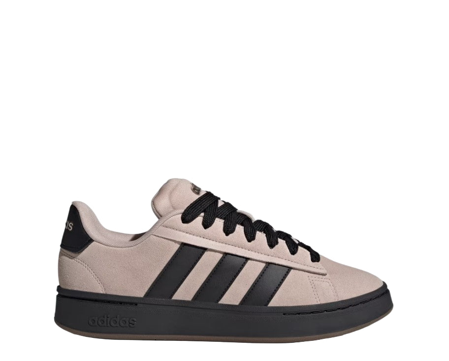 Beige Adidas sneaker with black stripes and sole on a light gray background