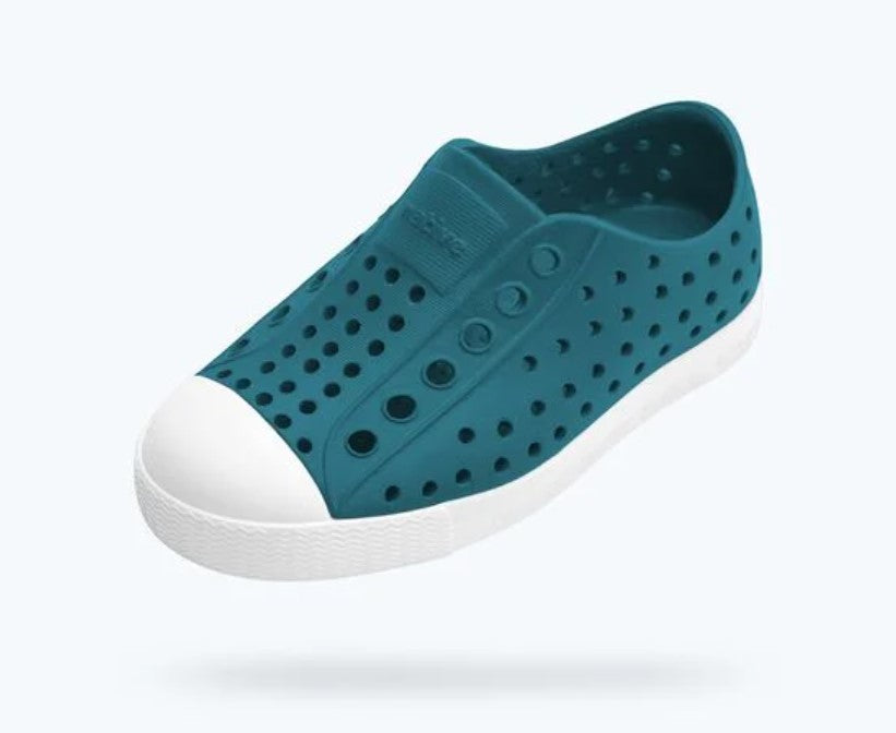 Teal slip-on shoe with white sole on a light gray background