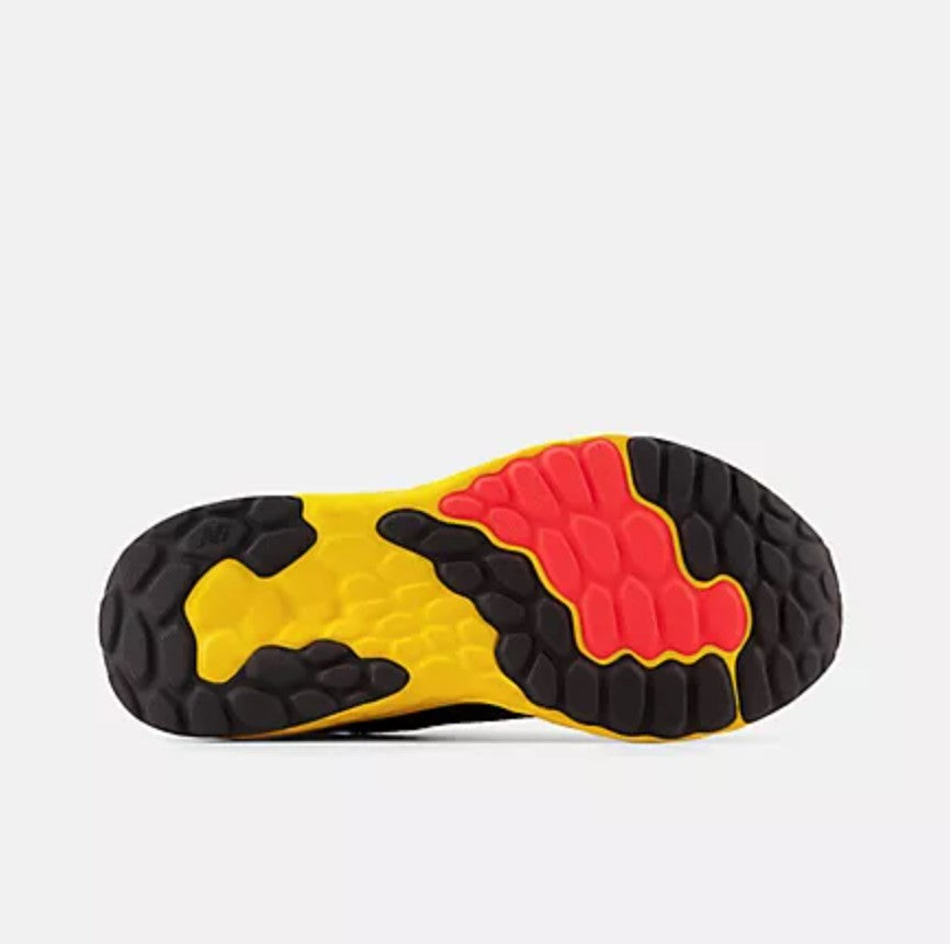 Close-up of a shoe sole with yellow, black, and red pattern on a white background