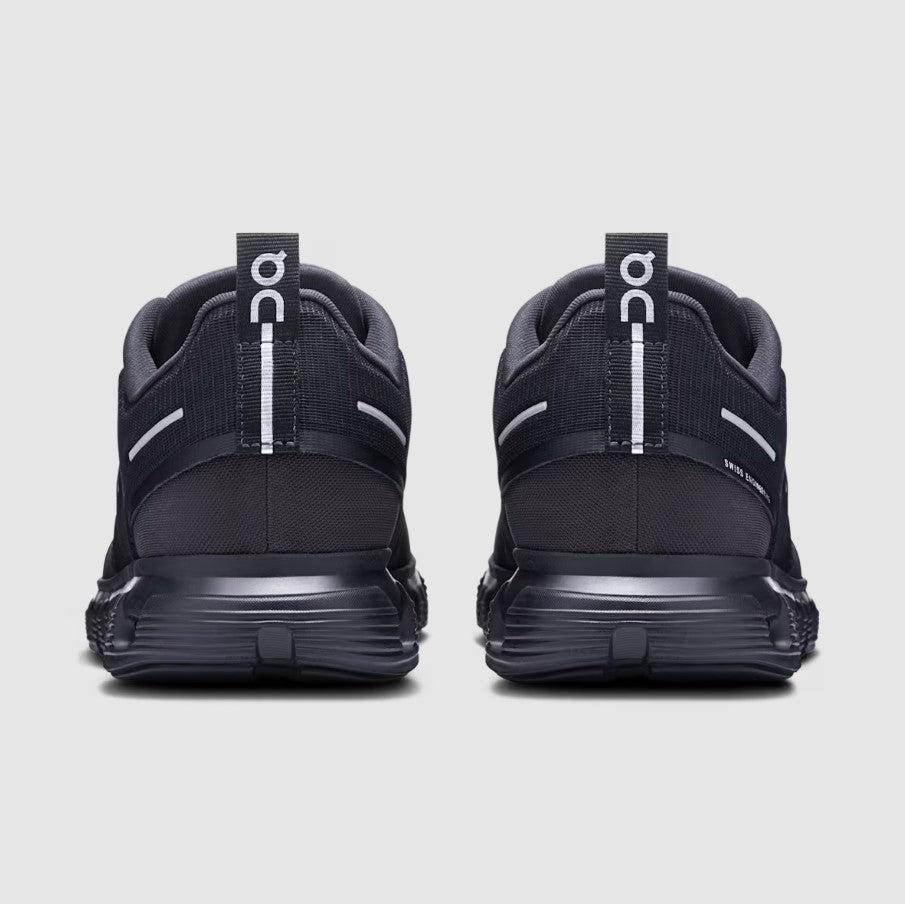 Black running shoes with visible 'On' branding on a light gray background