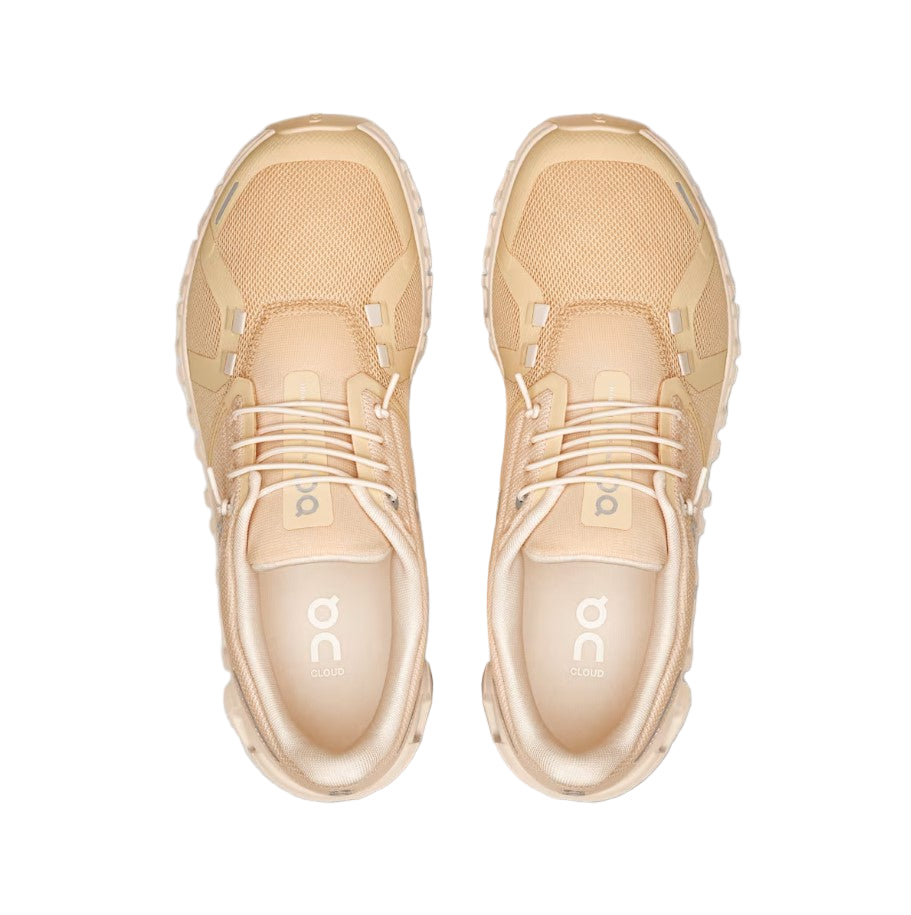 Pair of beige sneakers on a white background
