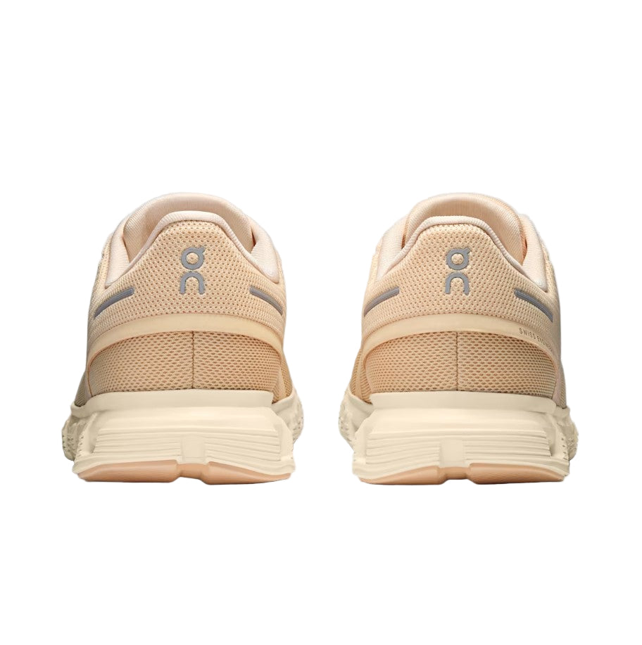 Beige running shoes with a visible brand logo on a white background