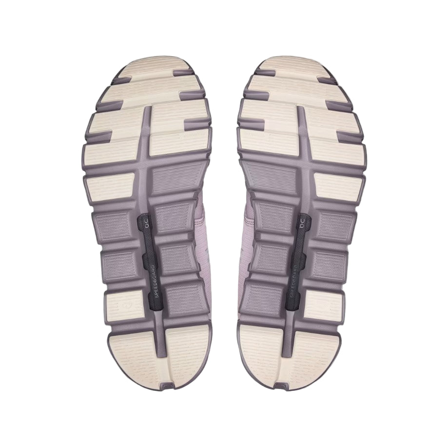 bottom view of mauve and beige shoe soles on a light gray background