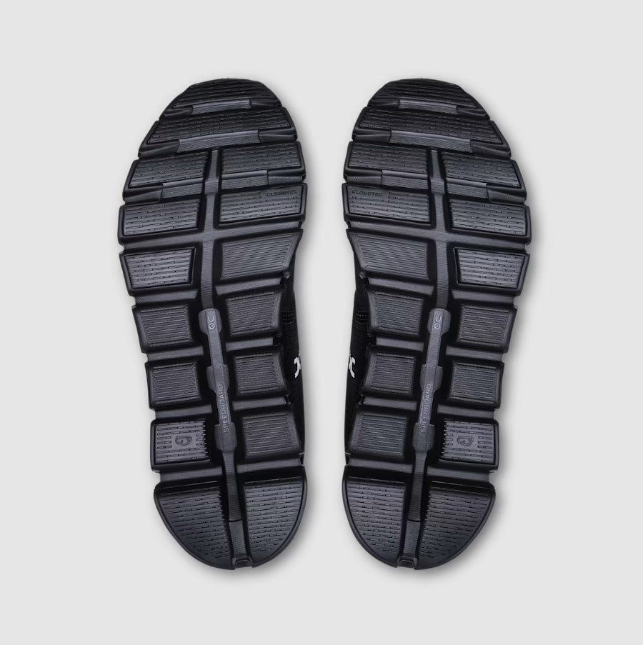 Pair of black shoe soles with a square/rectangle tread pattern on a light gray background