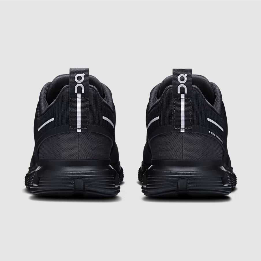 Black athletic shoes with visible branding on a light gray background