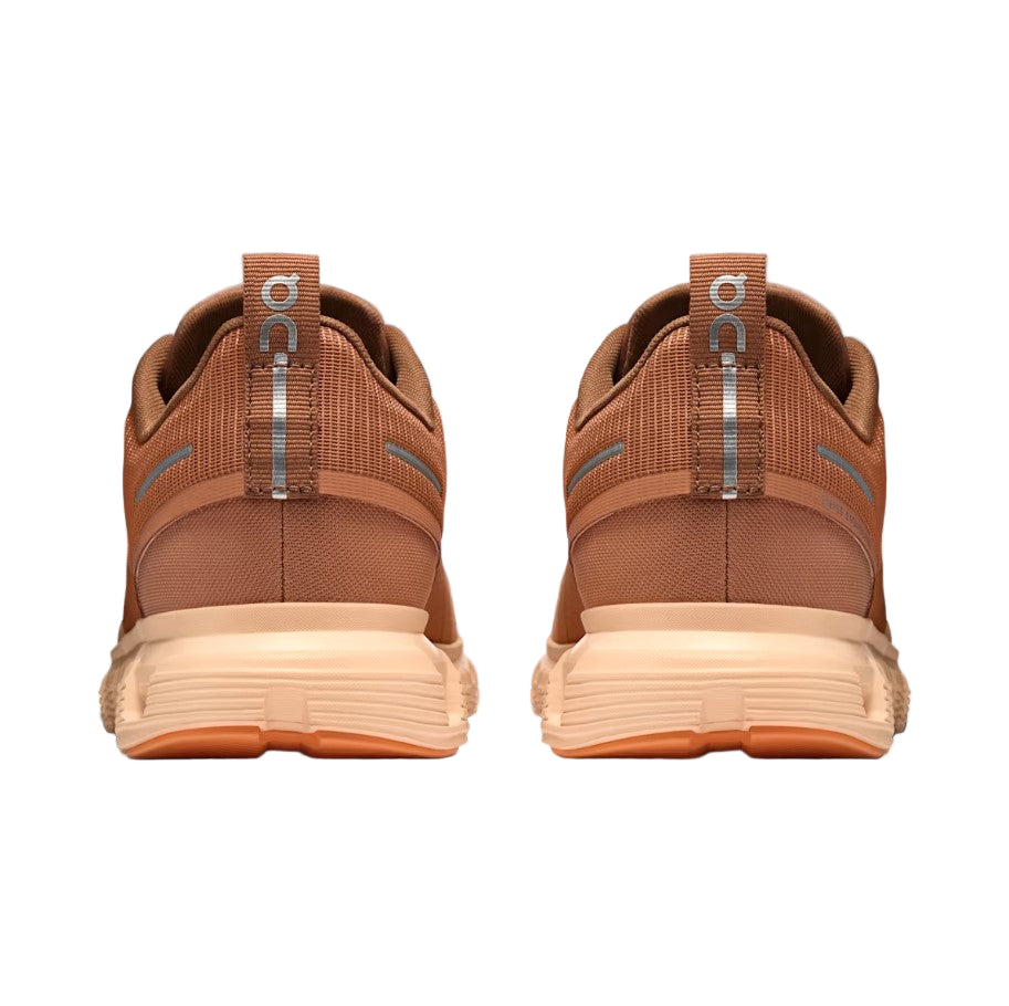 Brown athletic shoes with a visible brand logo on a white background