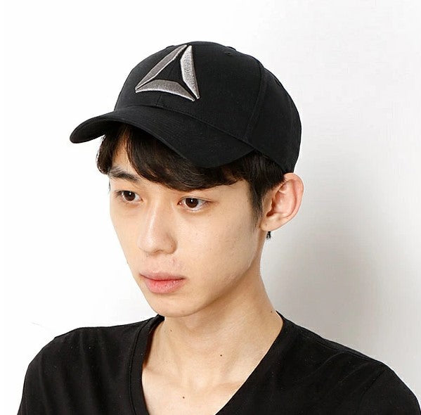 Person wearing a black cap with a logo on a white background