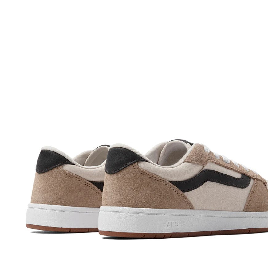 Pair of tan and beige sneakers with black accents on a white background
