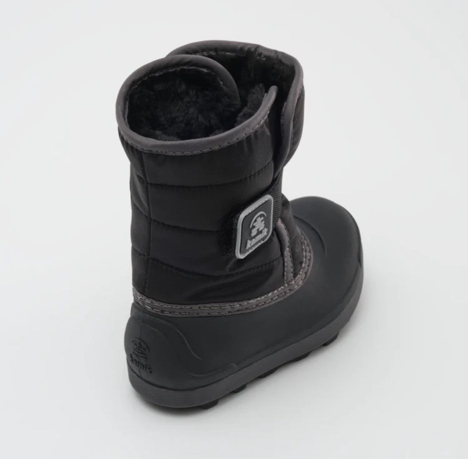 a black kamik boot from the back, featuring a black rubber sole and black fur lining