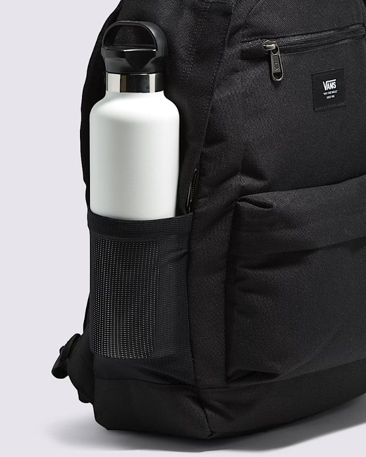 Black backpack with a white water bottle in a side pocket on a light gray background