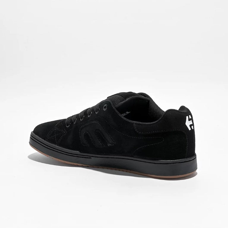 Black sneaker with a white logo on a light gray background