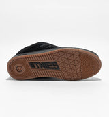 Black sneaker with a brown sole with 'Etnies' branding on a white background