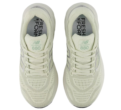 Pair of light green New Balance 880 shoes on a white background