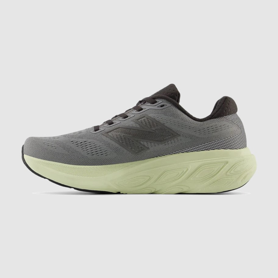 Gray running shoe with a green sole on a light gray background