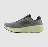 Gray running shoe with a green sole on a light gray background