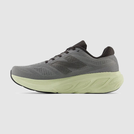 Gray running shoe with a green sole on a light gray background