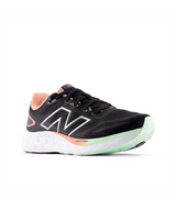 Black running shoe with green sole on a white background