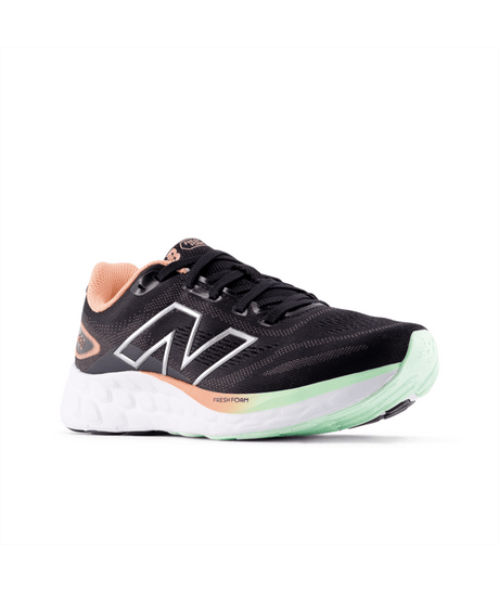 Black running shoe with green sole on a white background