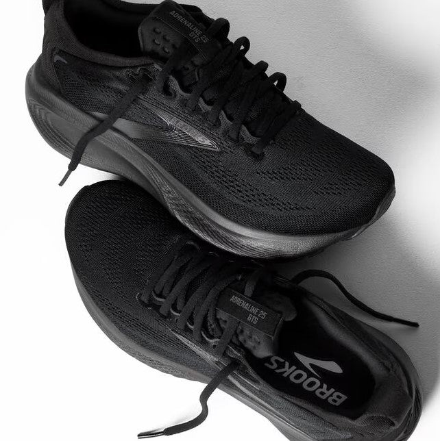 Black running shoes with visible brand logo on a light gray background