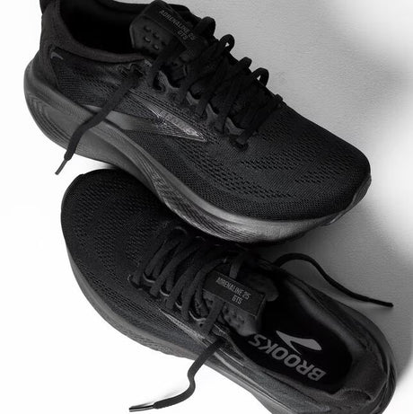 Black running shoes with visible brand logo on a light gray background