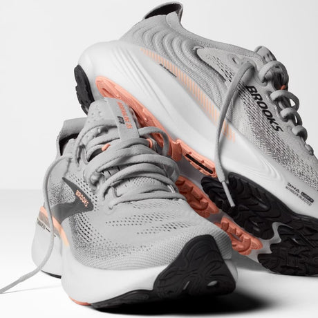 Gray running shoes with orange accents on a white background