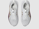 White running shoes with gold accents on a light gray background