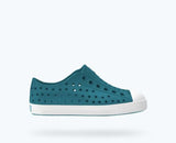 Teal shoe with white sole on a light gray background