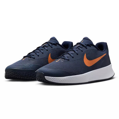 pair of navy Nike shoes with an orange-bronze swoosh and a white and black sole