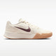 A beige nike shoe with a brown swoosh and a white and gum sole