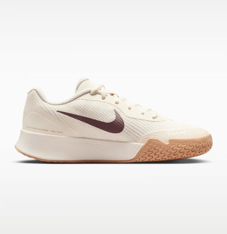 A beige nike shoe with a brown swoosh and a white and gum sole