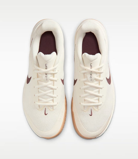 a pair of beige nike shoes with a brown swoosh and a white and gum sole from a top down view
