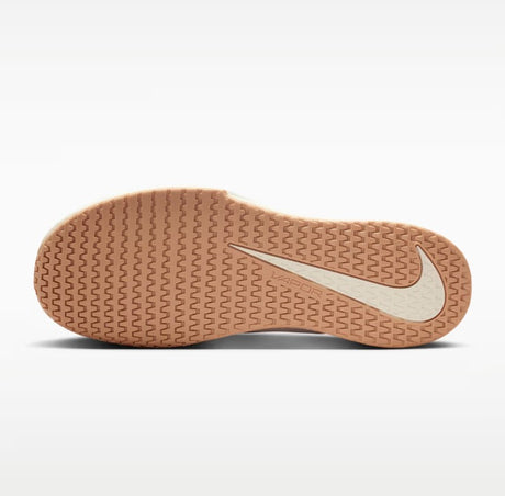 A gum coloured shoe sole with a white swoosh incorporated into the tread design