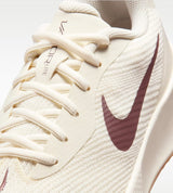 A close up of a beige and brown nike tennis shoe