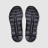 Top view of black sandals with textured sole on a light gray background