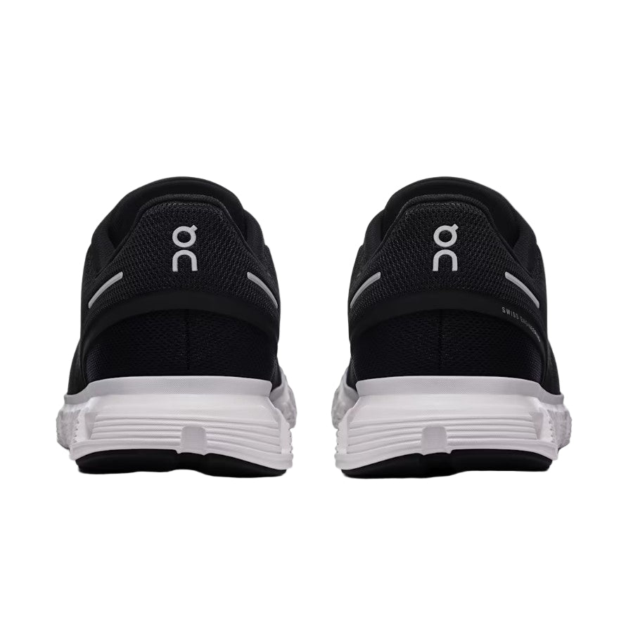 Black running shoes with white sole on a light gray background