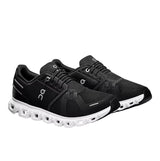 Black running shoes with white sole on a light gray background