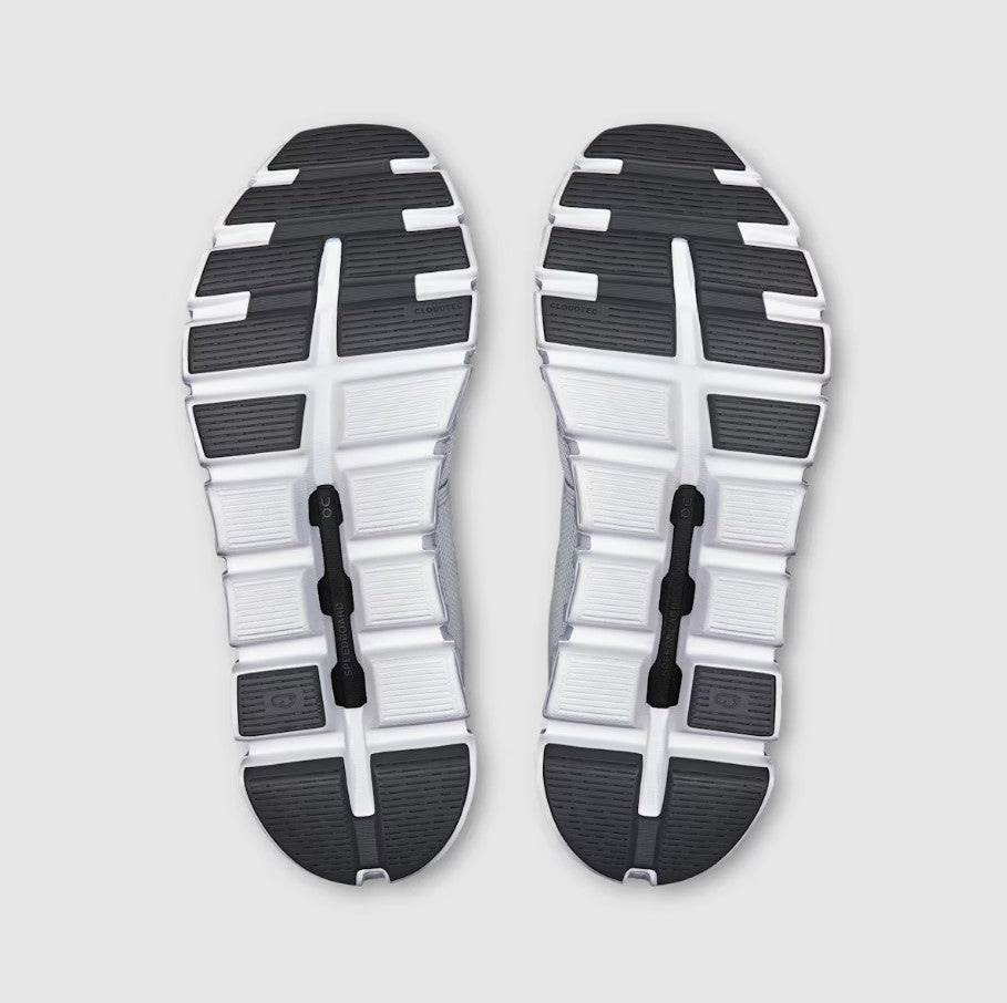 Bottom view of White and black shoe soles on a light gray background