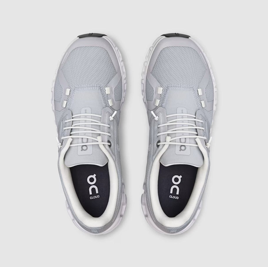 Gray athletic shoes with white soles on a light gray background