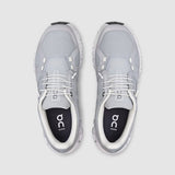 Gray athletic shoes with white soles on a light gray background