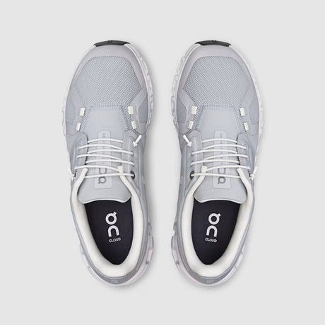 Gray athletic shoes with white soles on a light gray background
